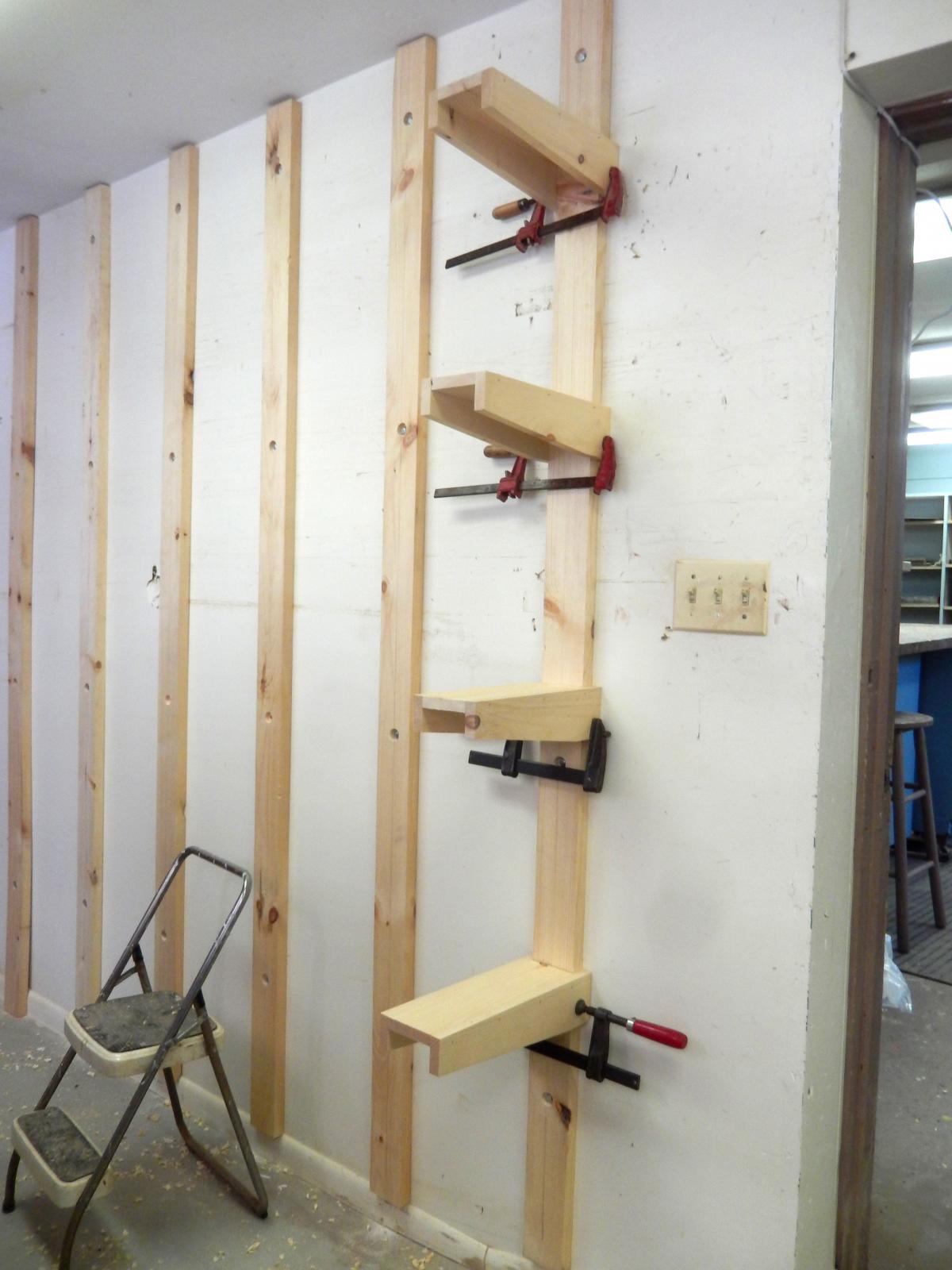 Mario temporarily clamped the brackets over the posts for alignment and leveling before driving the screws to lock them in place.